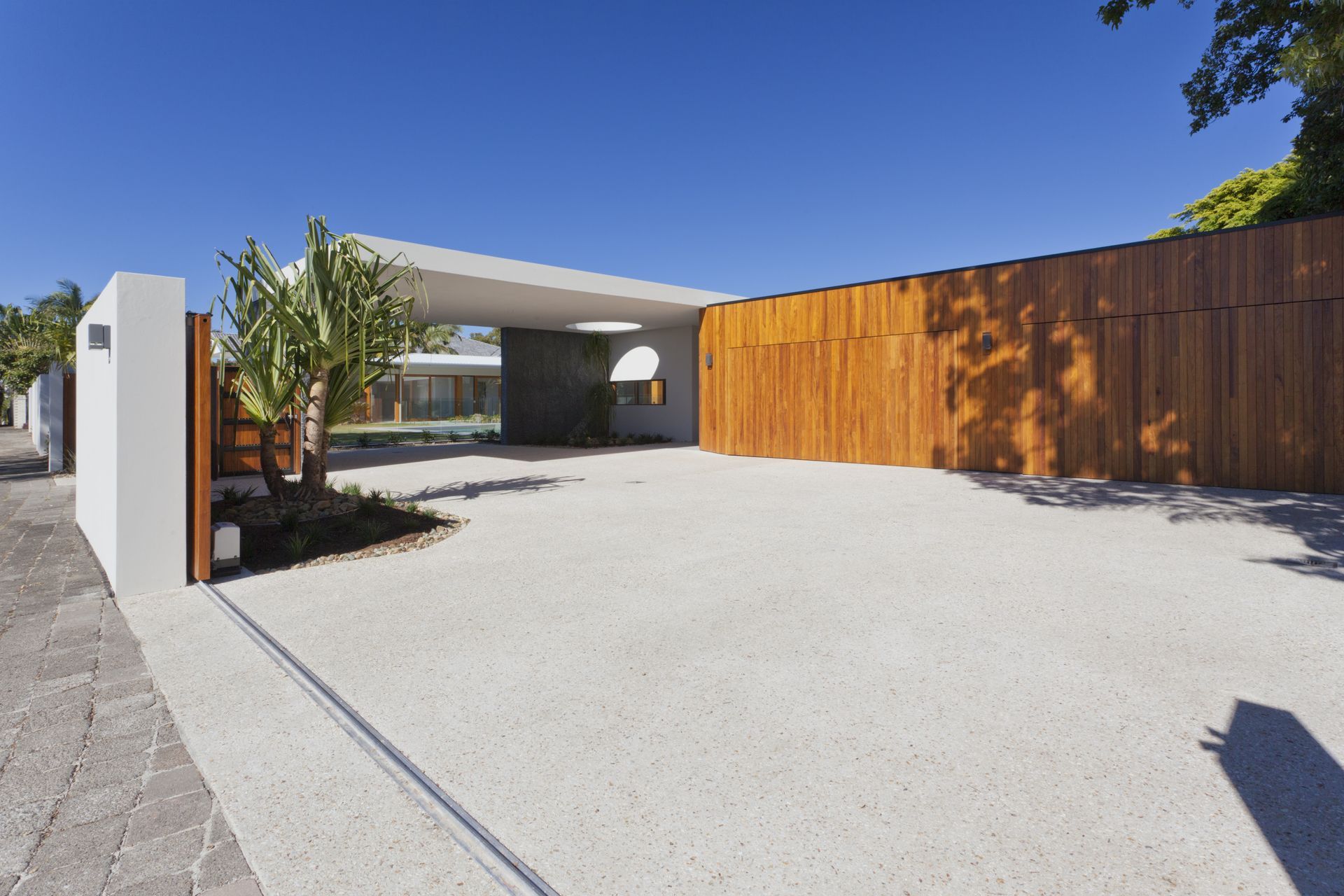 Exterior View of a Modern House Entrance With a Wooden Gate, Gravel Driveway — All Around Concreting in Mullumbimby, NSW