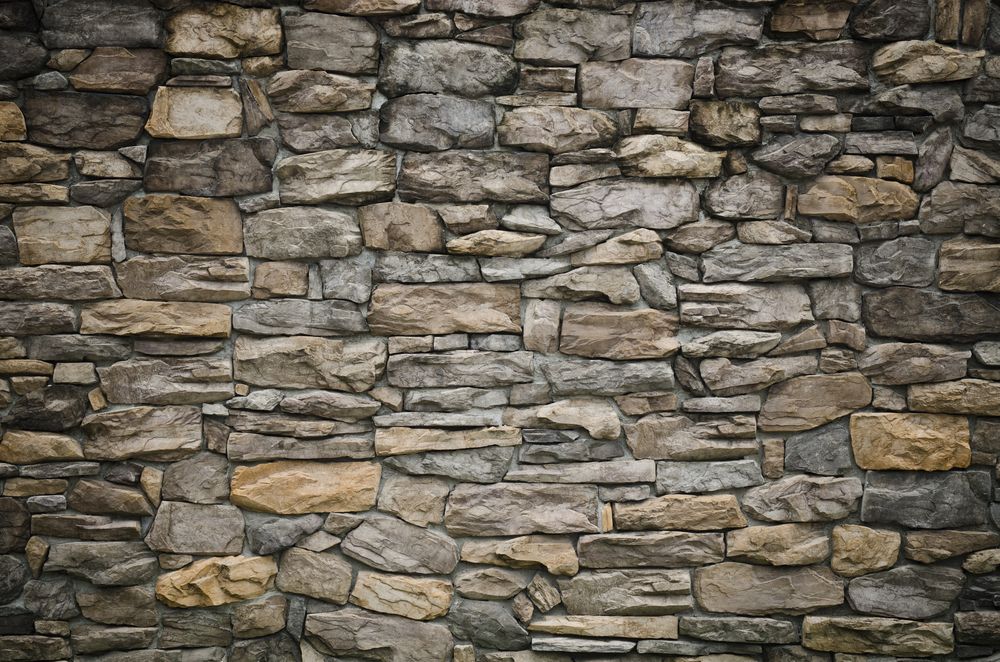 Stone Wall With Varying Shades of Gray, Tan, and Brown Bricks — All Around Concreting in Wollongbar, NSW