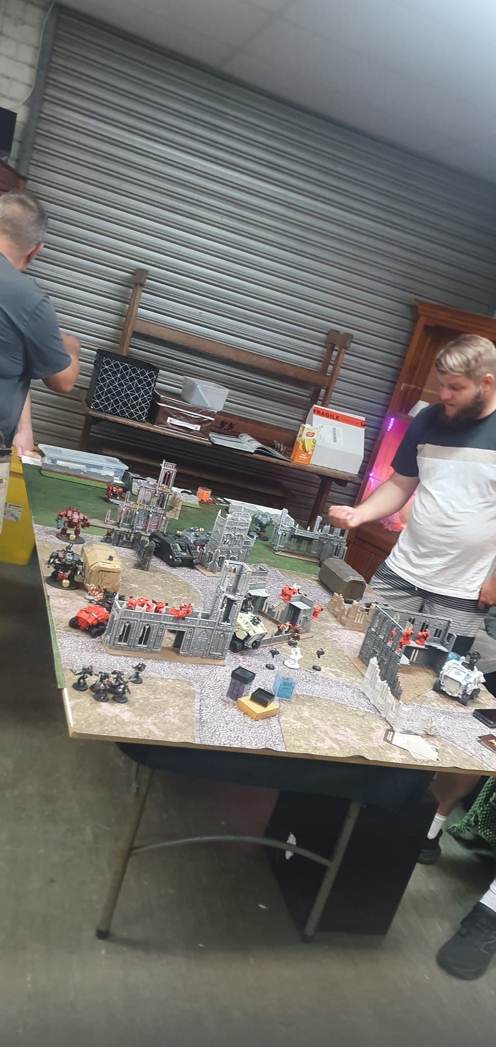 Two People Playing a Tabletop War Game With Miniatures on a Large Table — Grim Gaming & Hobbies in Bundaberg Central, QLD