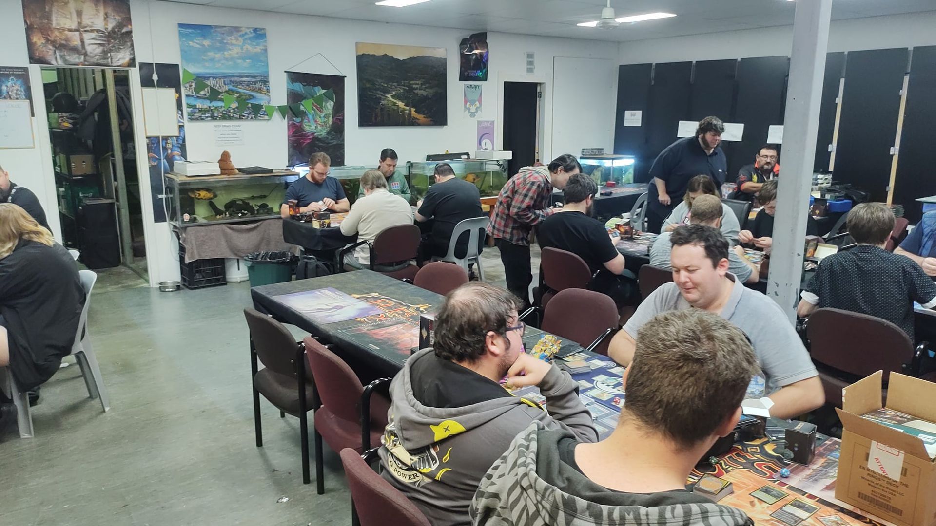 People Playing Board Games at Tables in a Brightly Lit Room — Grim Gaming & Hobbies in Bundaberg Central, QLD