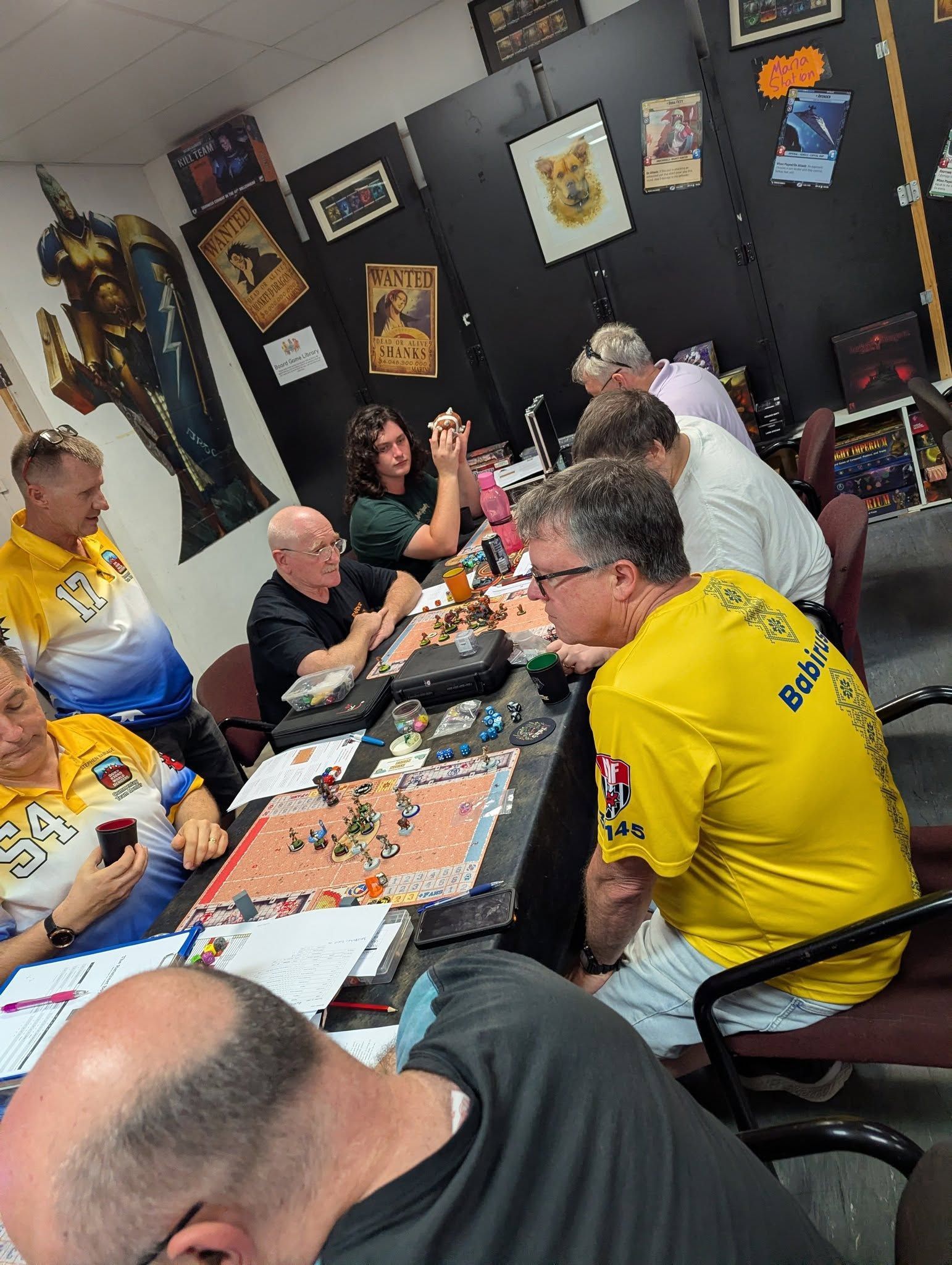 Group of People Gathered Around a Table Playing a Board Game — Grim Gaming & Hobbies in Bundaberg Central, QLD