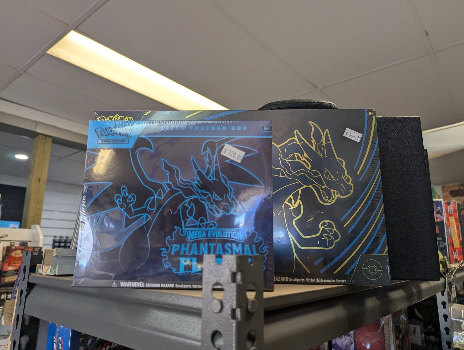 Two Pokémon Card Booster Boxes on a Shelf — Grim Gaming & Hobbies in Bundaberg Central, QLD