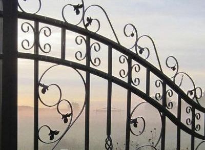 Un cancello in ferro battuto con un tramonto sullo sfondo