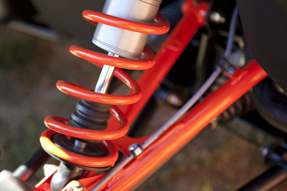 A Red Suspension Spring and Shock Absorber with Silver Hardware — Bundaberg Field Service in Woodgate, QLD