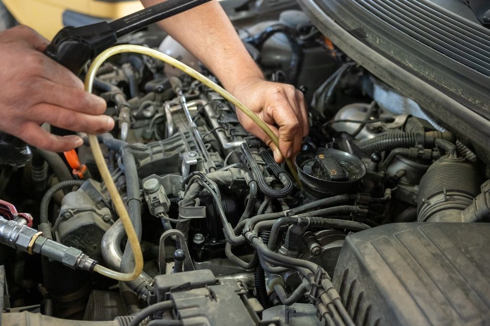 Mechanic working on a car engine with tools and hoses in the engine bay — Bundaberg Field Service in Bargara, QLD