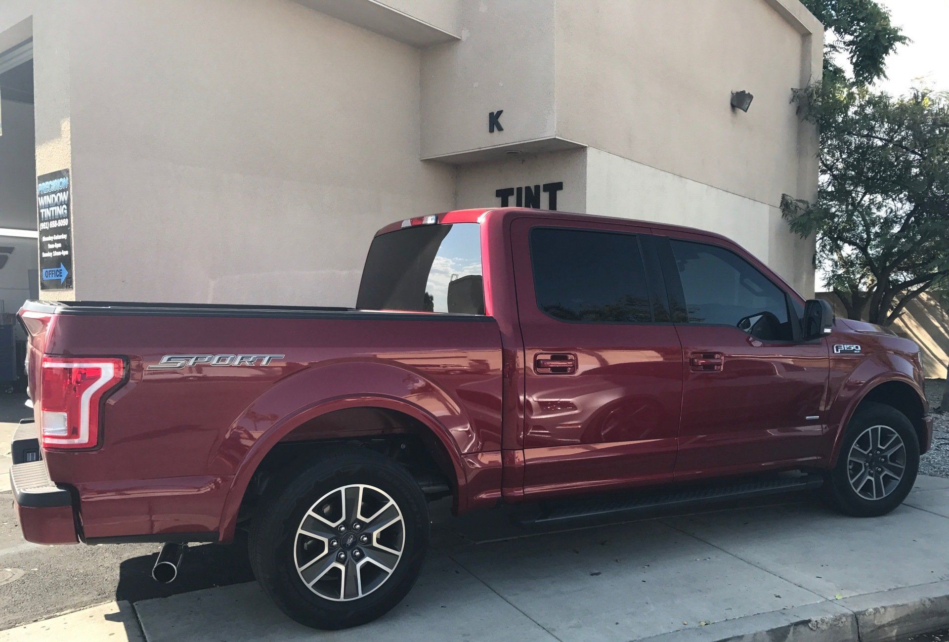 A red pickup truck is parked in front of a building
