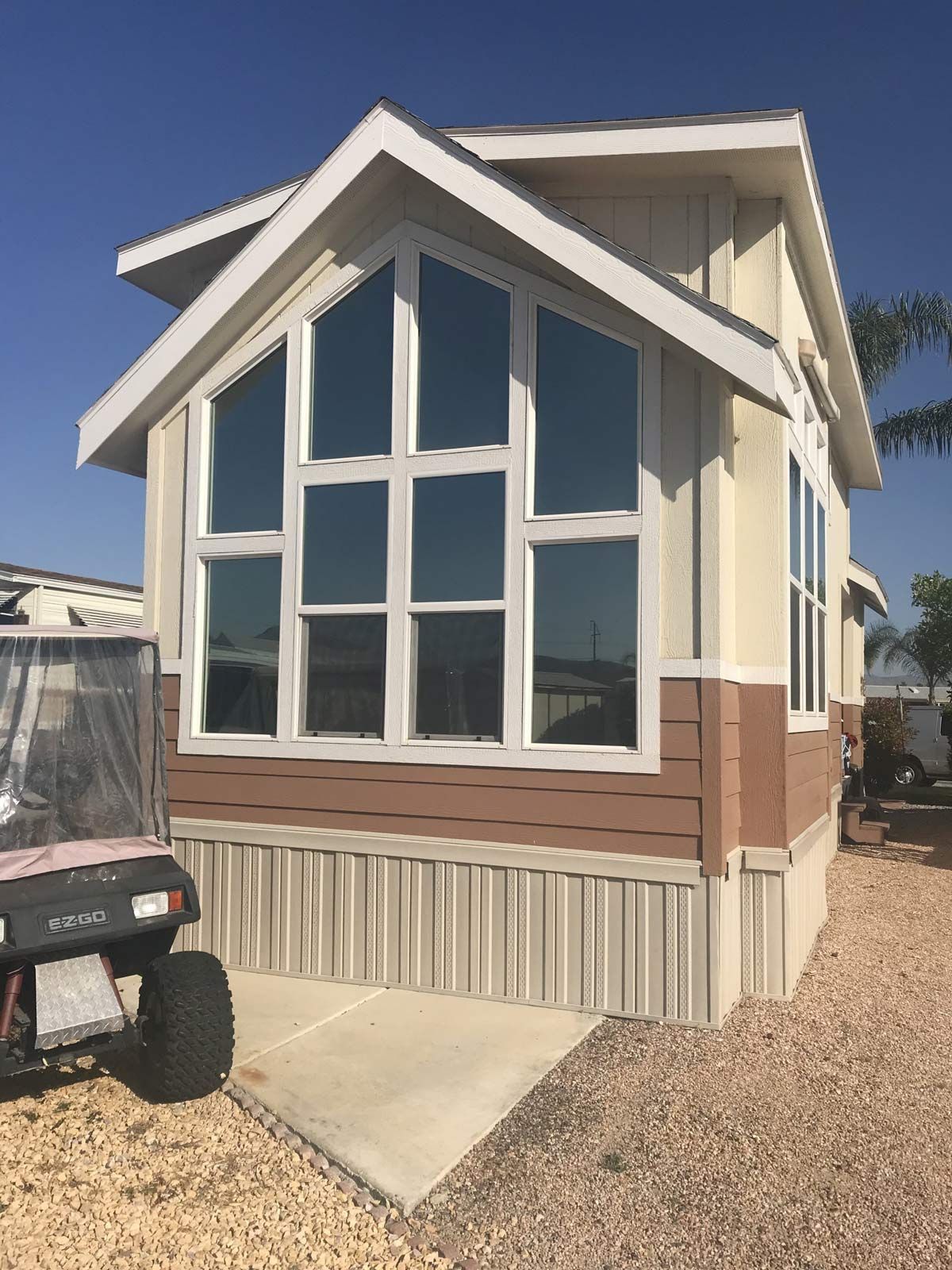 A mobile home with a golf cart parked in front of it