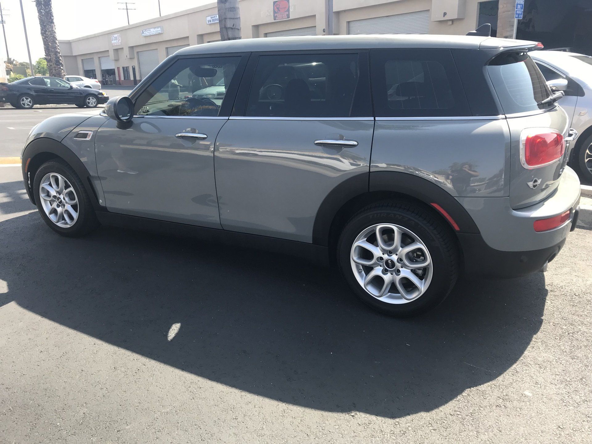 A gray Mini Cooper Clubman is parked on the side of the road
