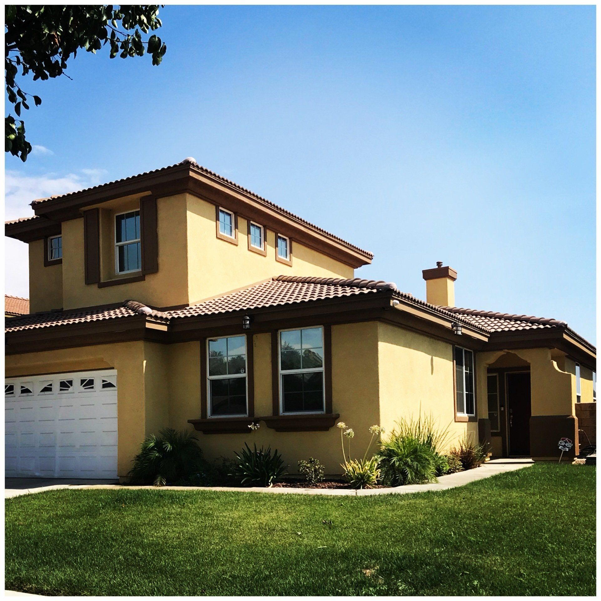 A large yellow house with a white garage door