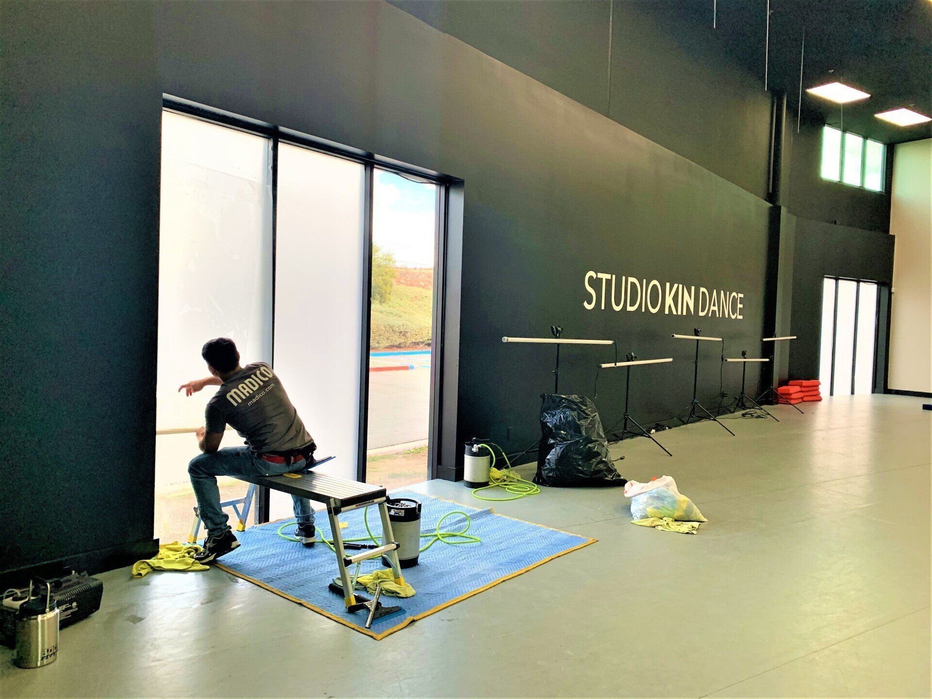 A man is sitting on a bench in a room cleaning a wind