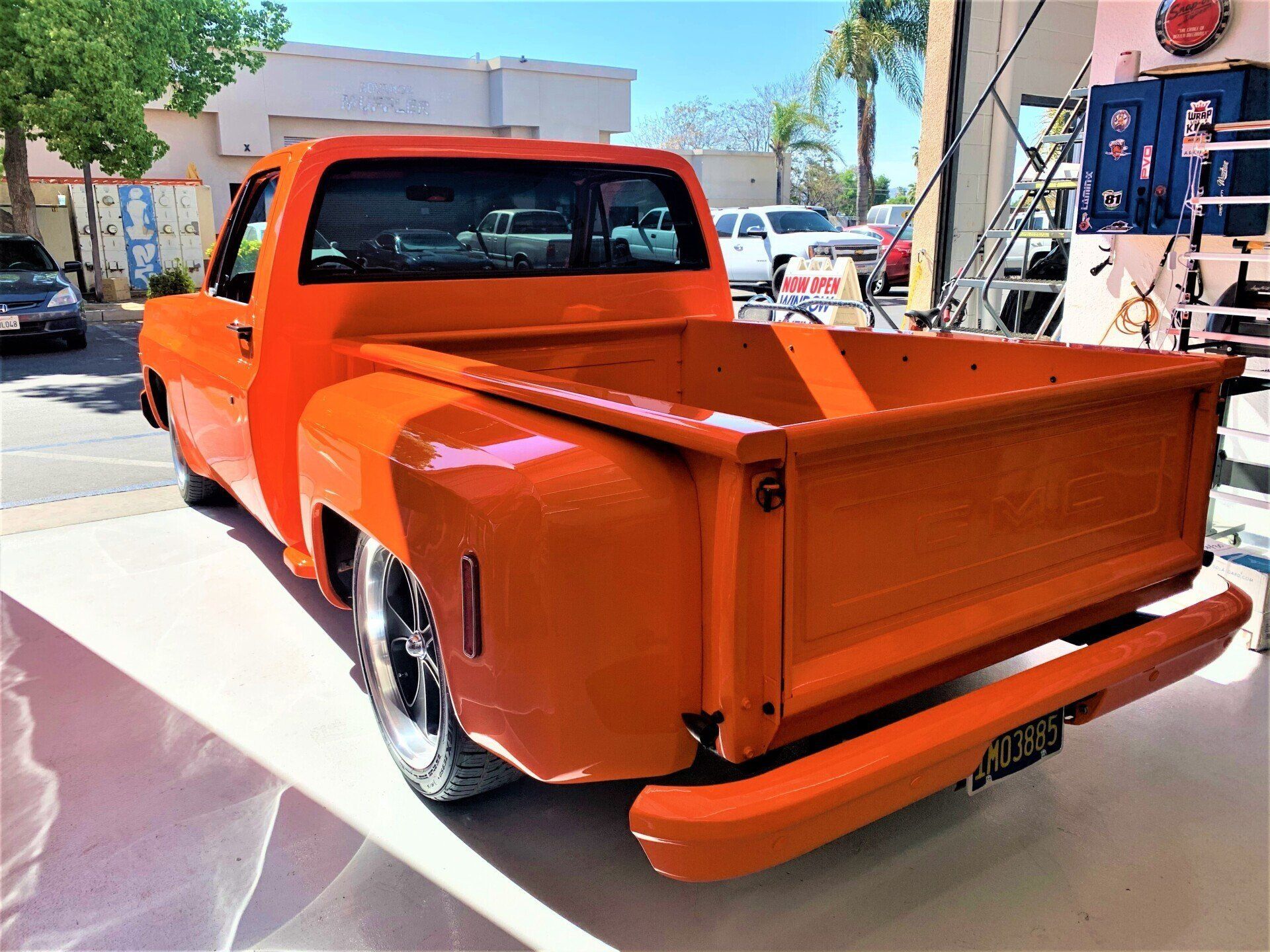 An orange truck is parked in front of a building