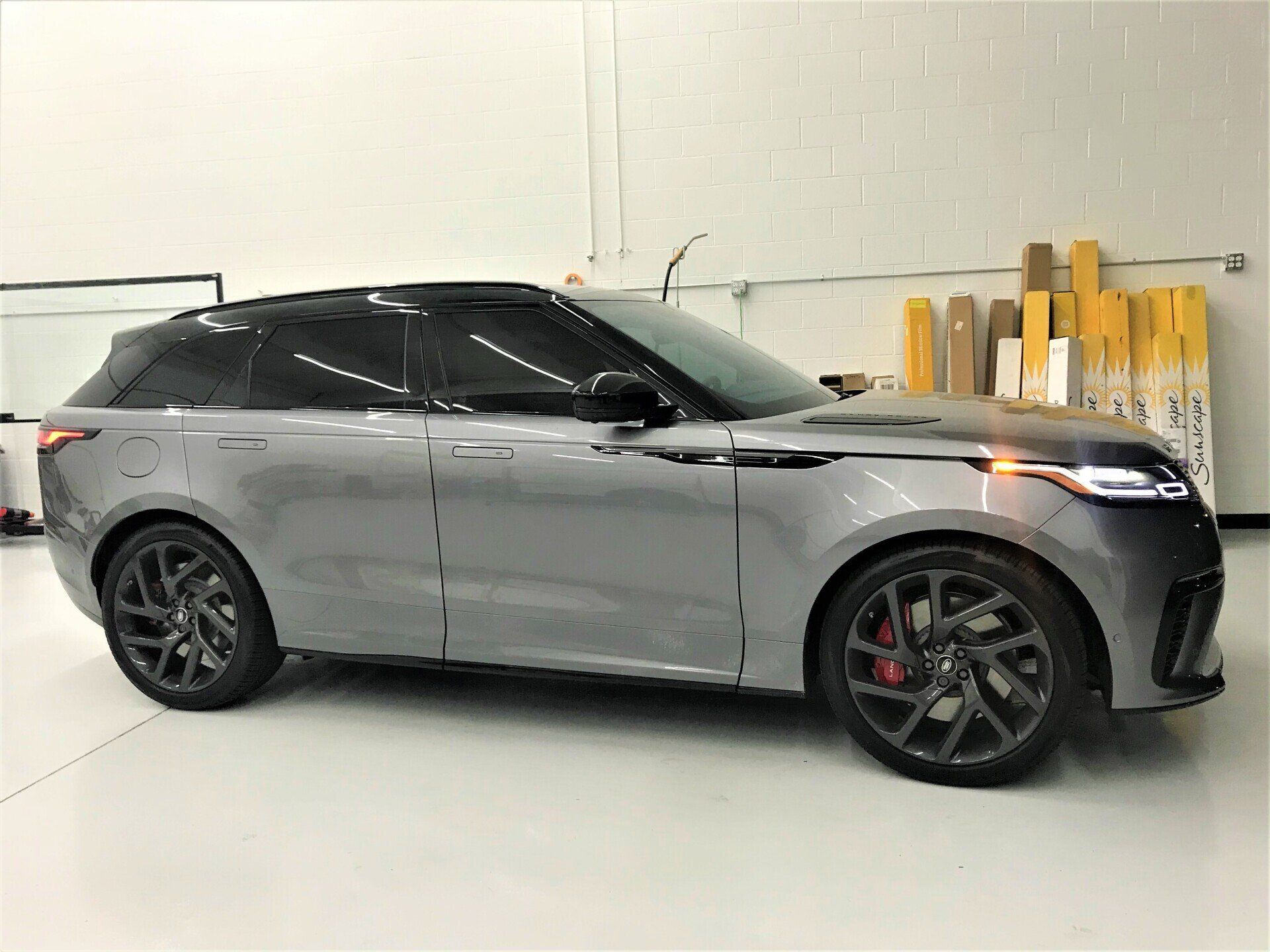 A gray Range Rover Velar is parked in a garage