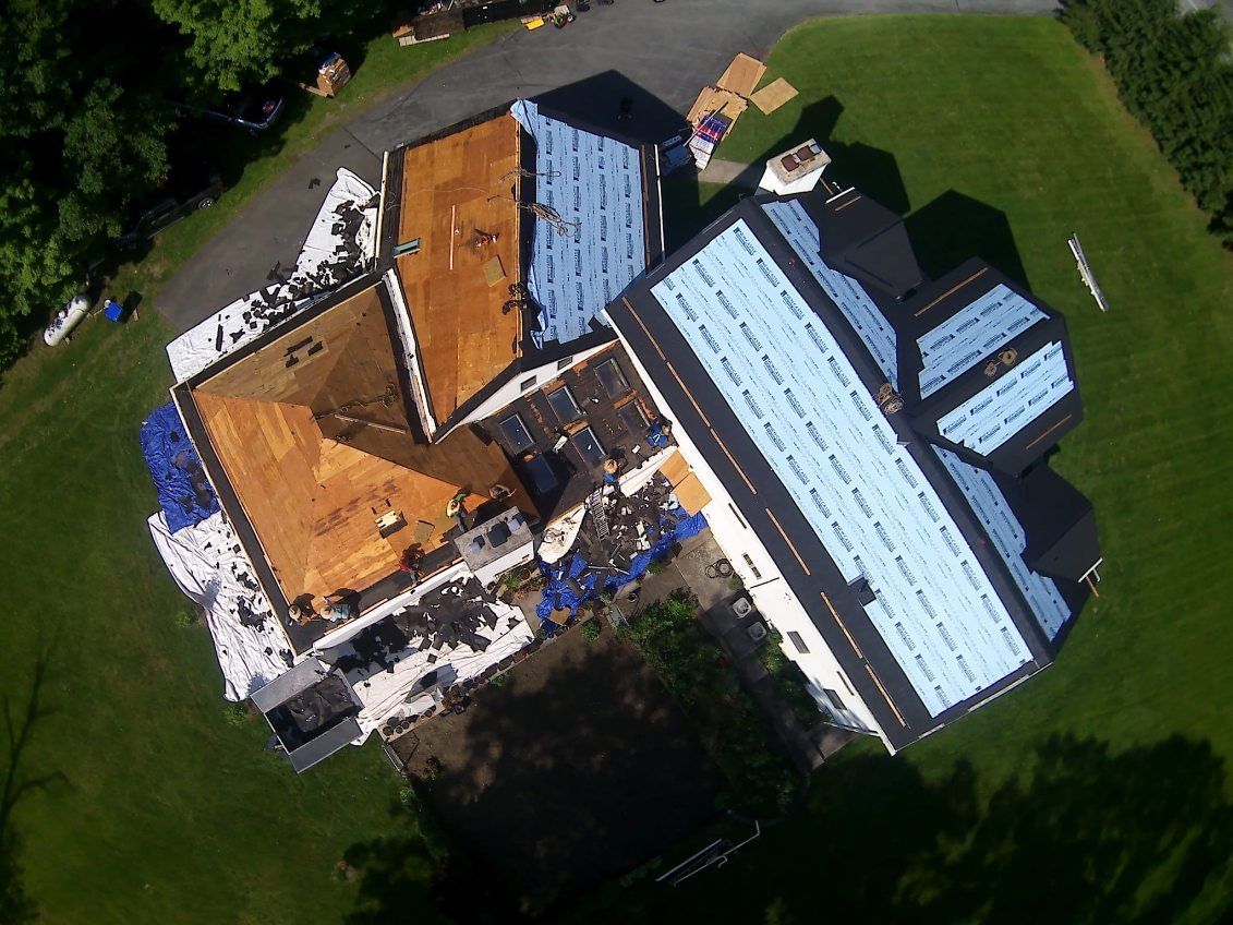 An aerial view of a house under construction with a blue roof.