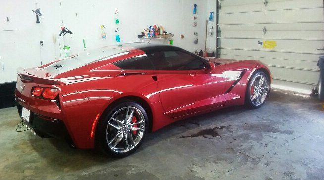 A red sports car is parked in a garage.