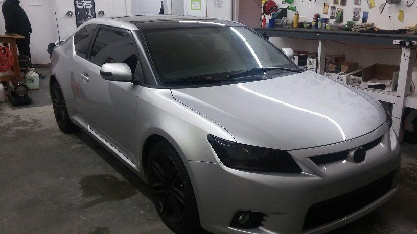 A silver car is parked in a garage.
