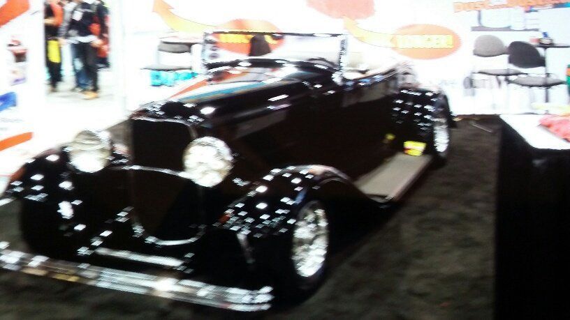 A black car is on display at a car show