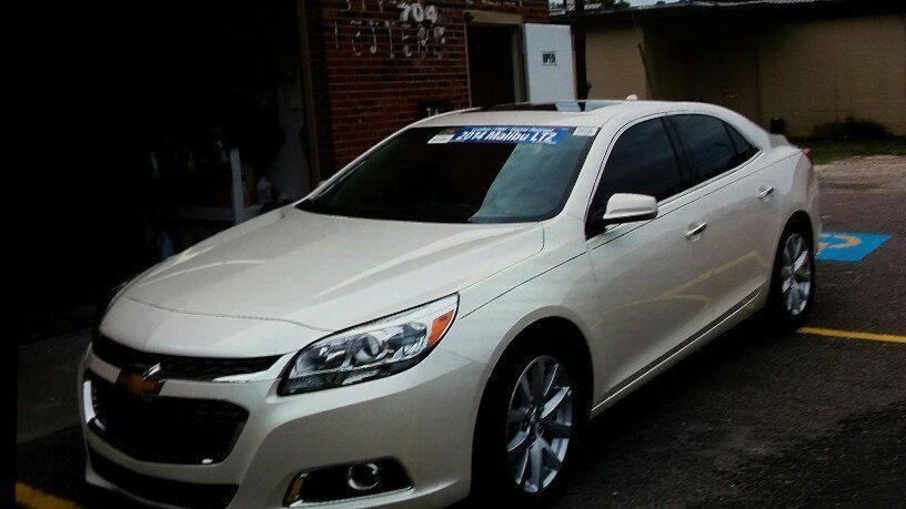A white car is parked in a handicapped parking spot