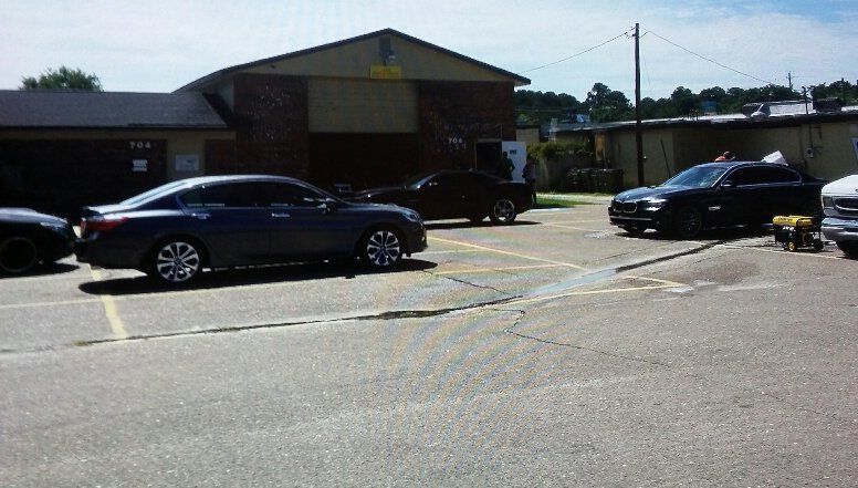 A parking lot with cars parked in front of a building.