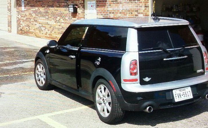 A black mini cooper is parked in a parking lot