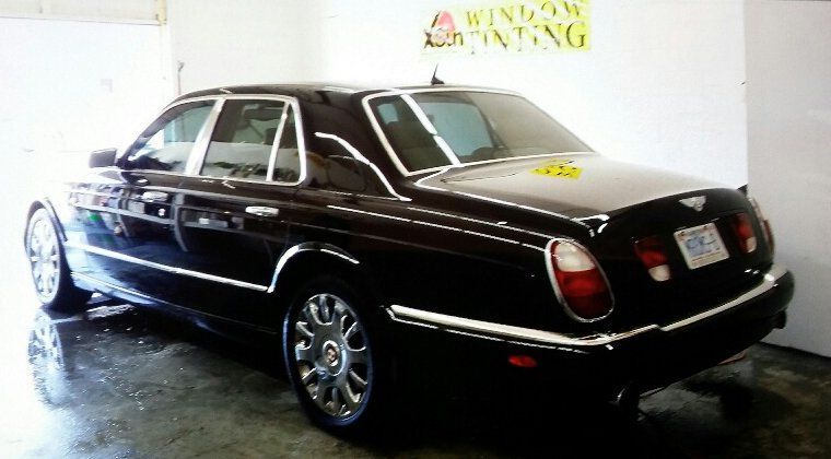 A black bentley is parked in a garage