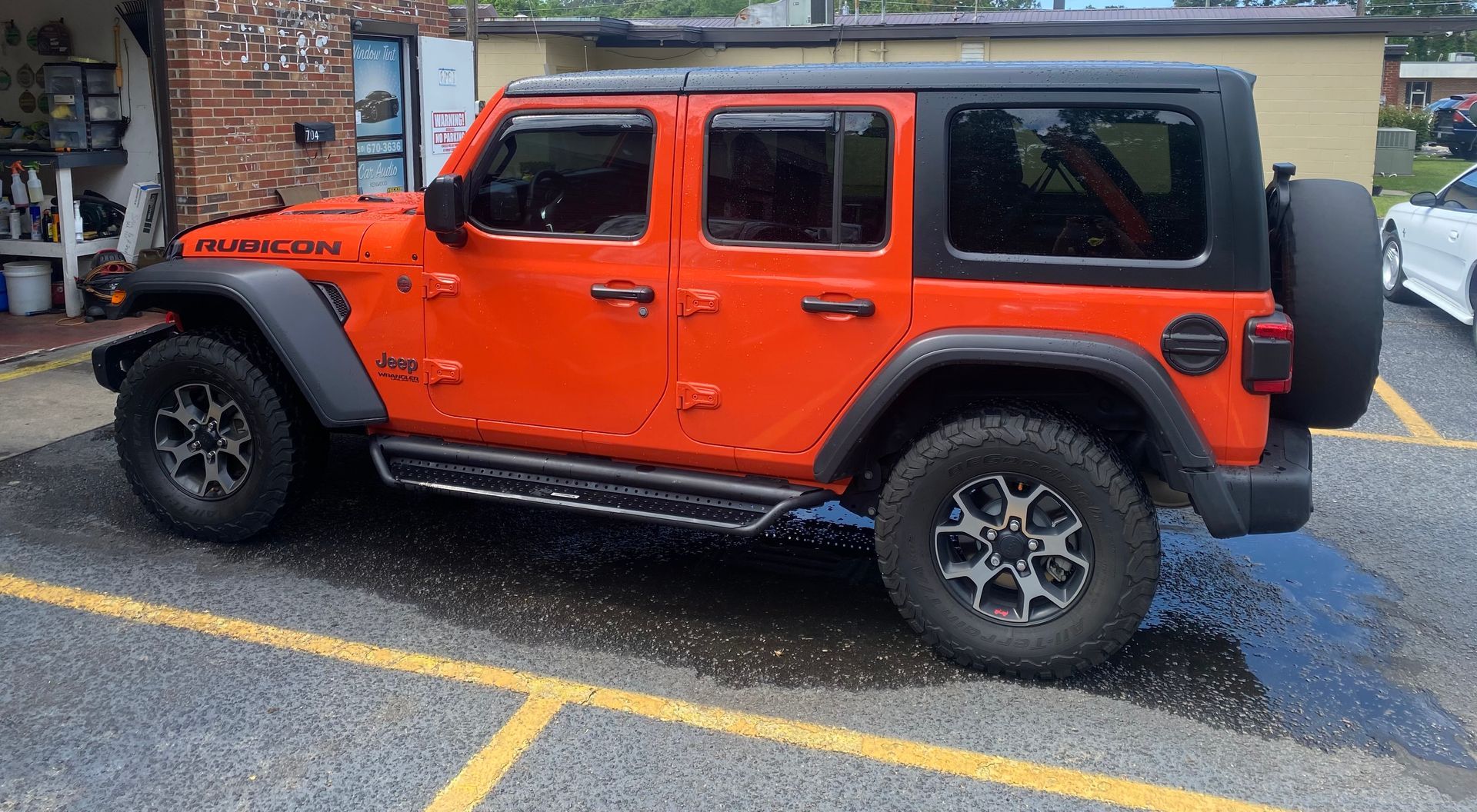 A red jeep is parked in a parking lot.