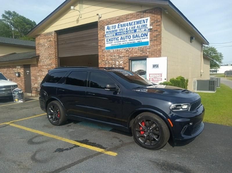 A black suv is parked in front of a building.