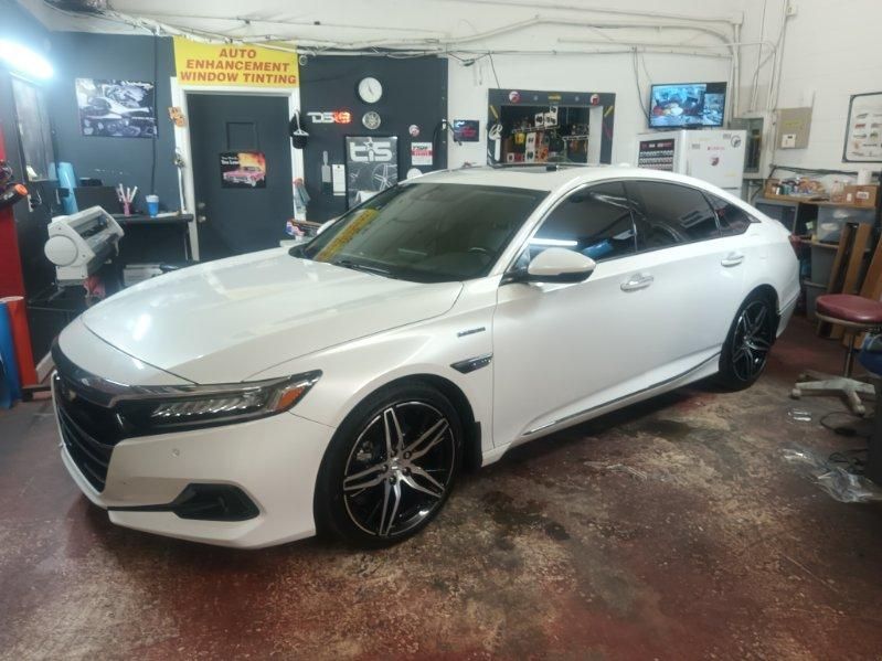 A white honda accord is parked in a garage.