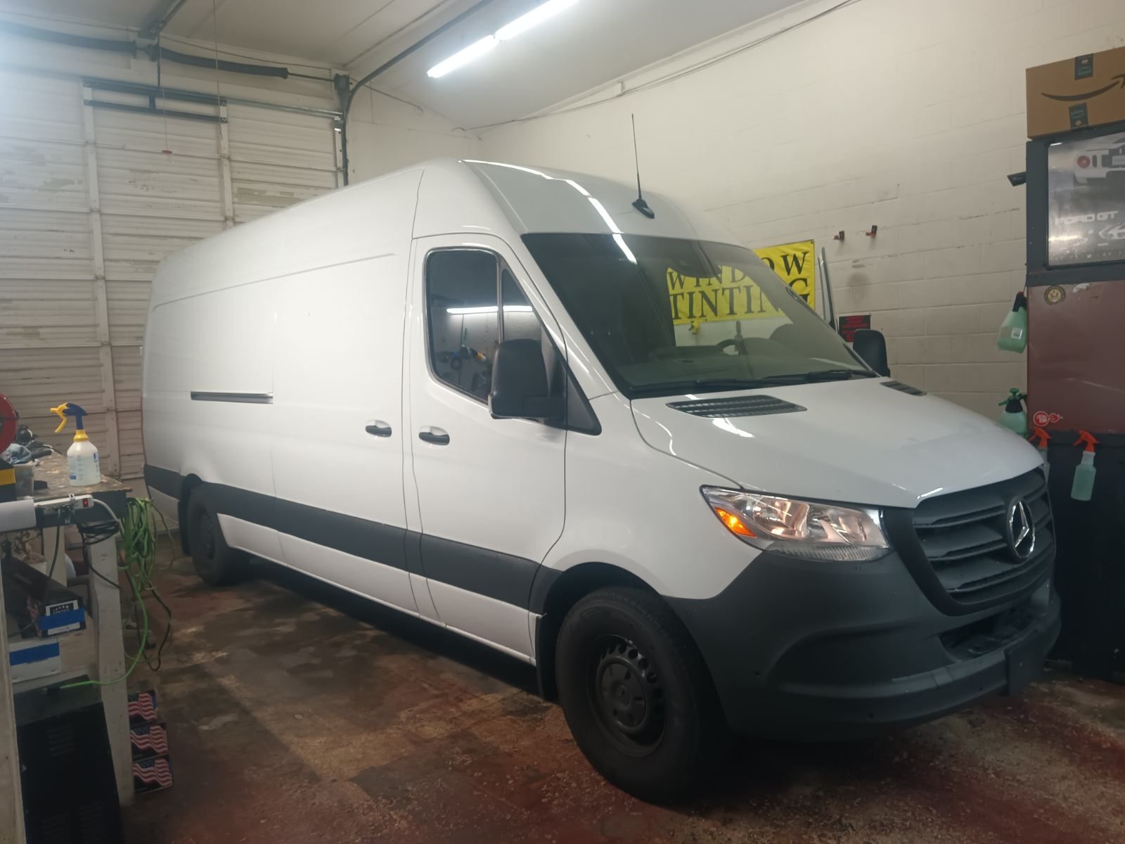 A white van is parked in a garage.