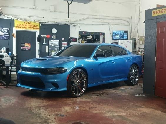 A blue dodge charger is parked in a garage