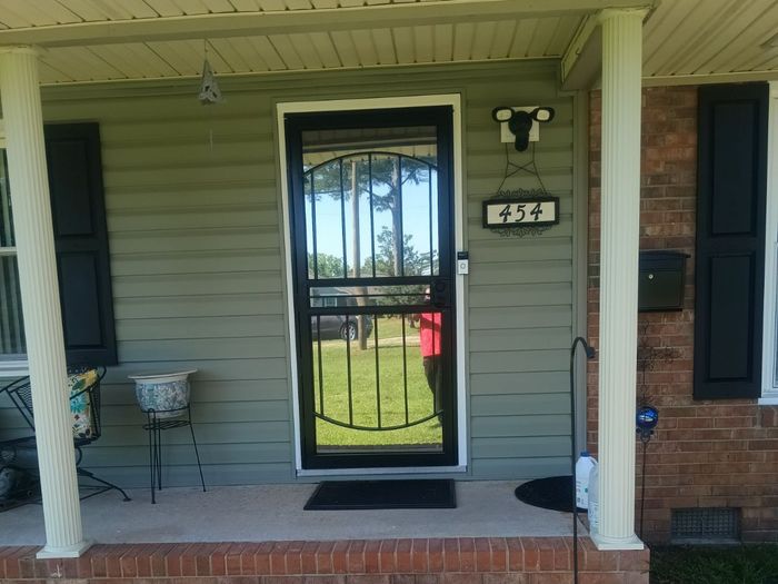 A house with a screen door and a sign that says 454