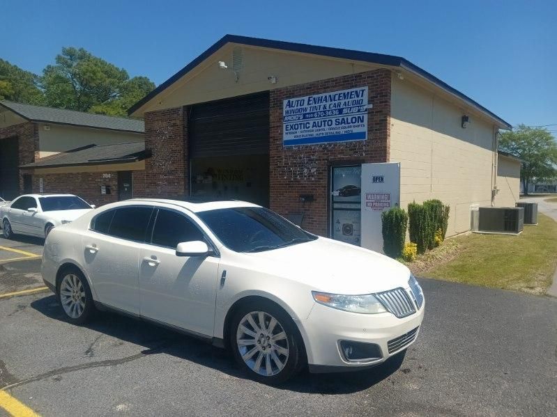 A white lincoln mkx is parked in front of a building.