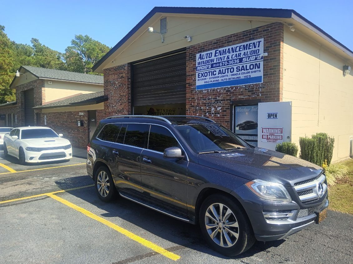 A mercedes benz gl 550 is parked in front of a building.