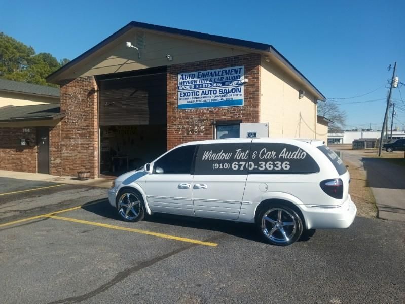 A white minivan is parked in front of a building