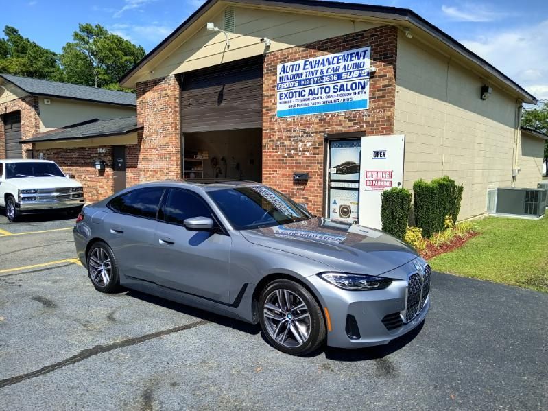 A silver car is parked in front of a brick building.