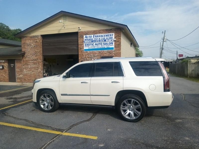 A white suv is parked in front of a brick building.