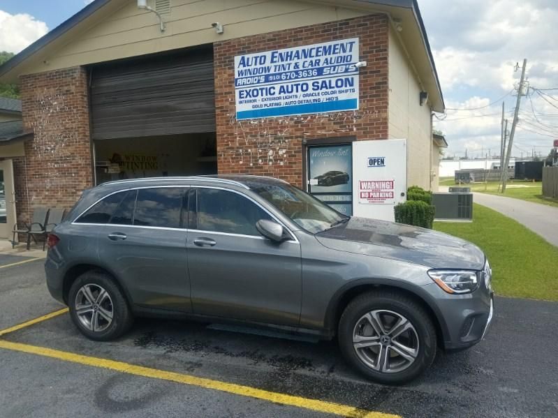 A gray suv is parked in front of a brick building.