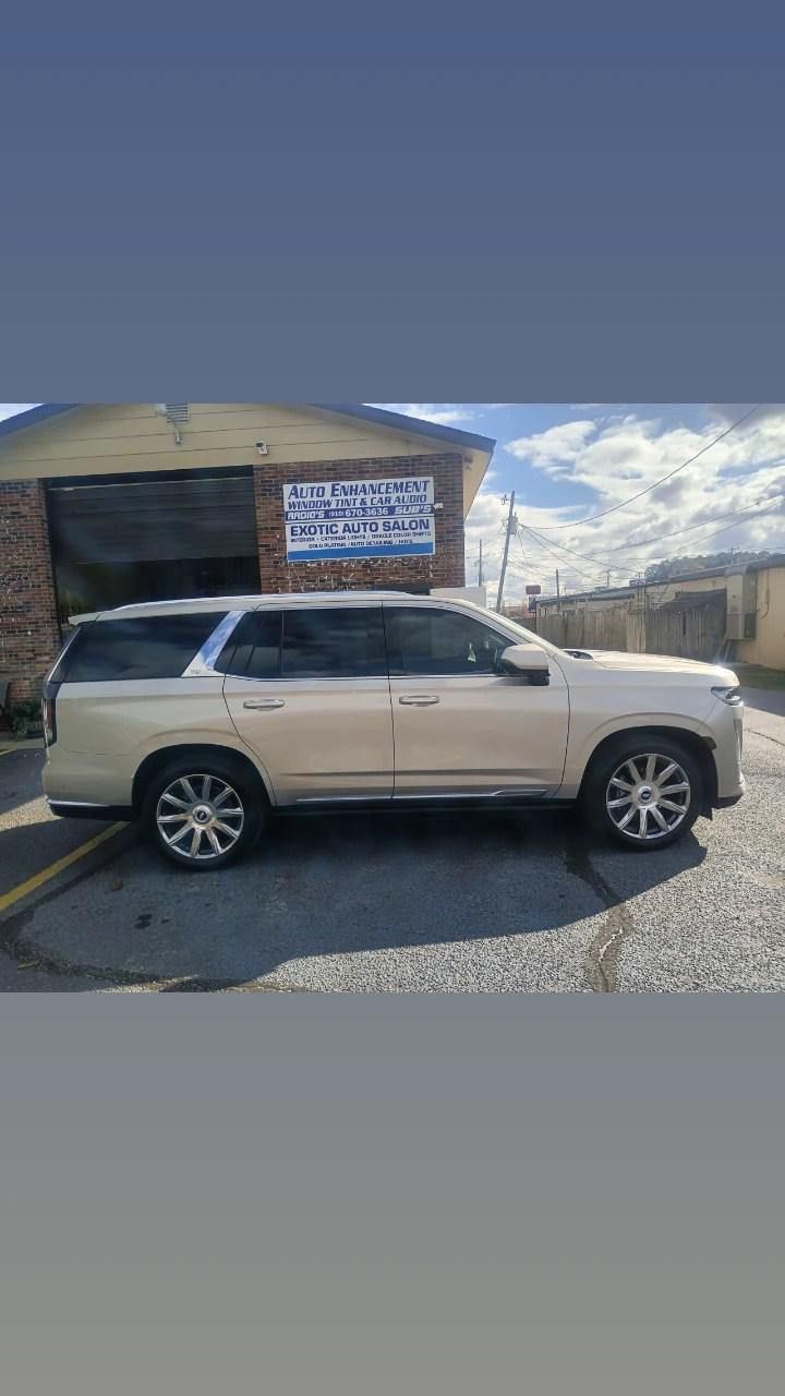 A white suv is parked in a parking lot in front of a building.