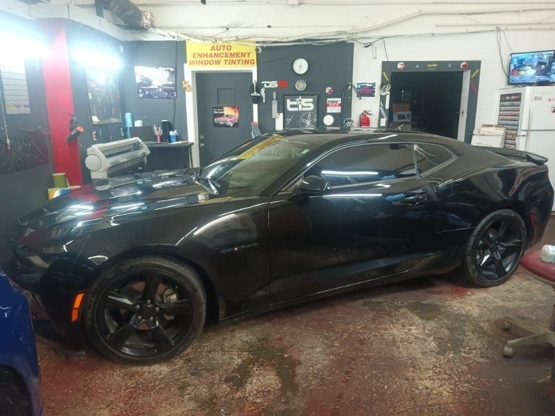 A black car is parked in a garage.