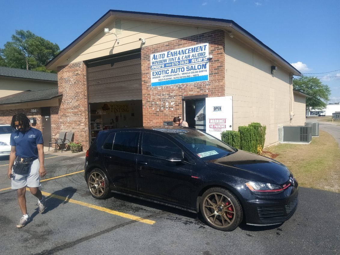 A black car is parked in front of a car wash