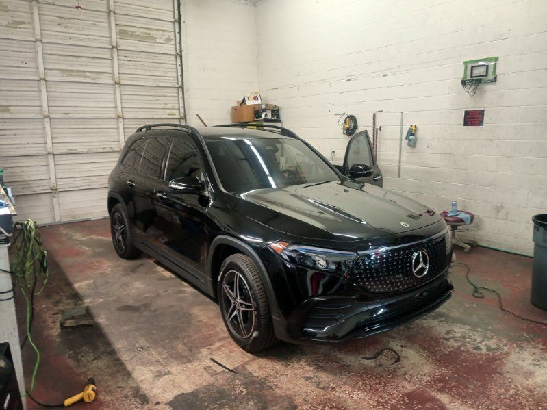 A black mercedes benz suv is parked in a garage.