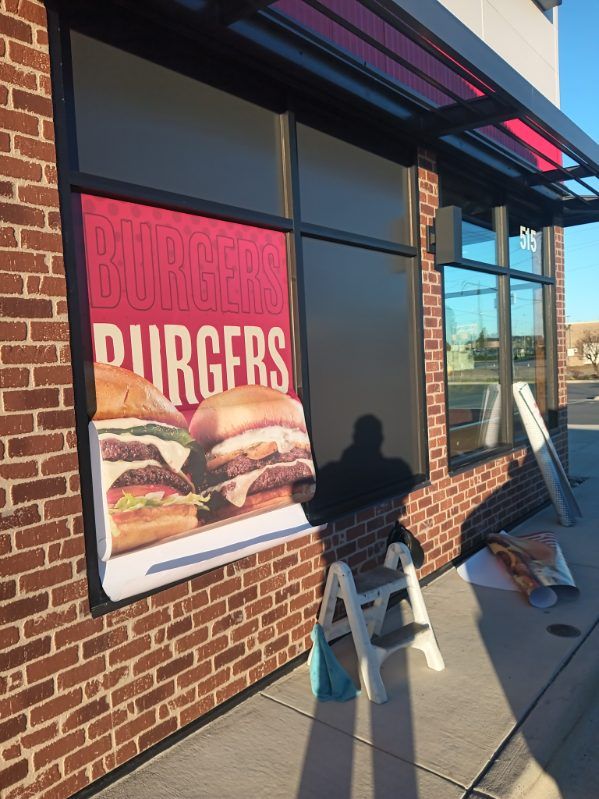 A brick building with a sign that says burgers on it