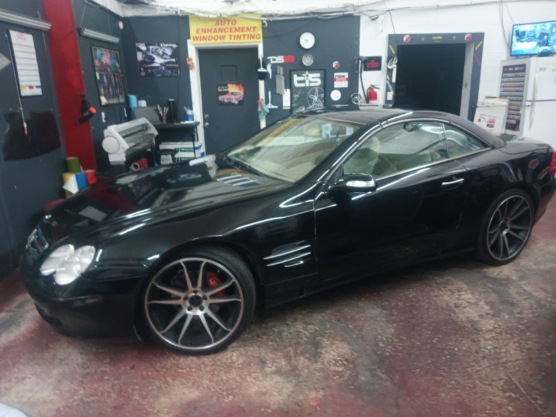 A black sports car is parked in a garage.