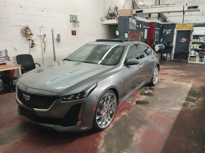 A silver cadillac is parked in a garage.