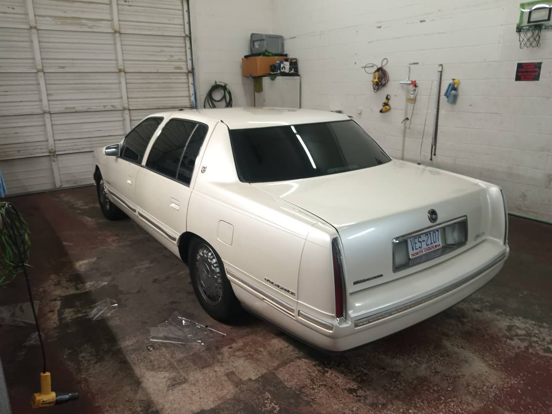 A white cadillac is parked in a garage