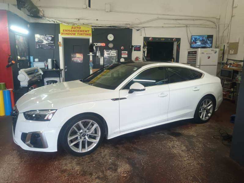 A white audi a5 is parked in a garage.