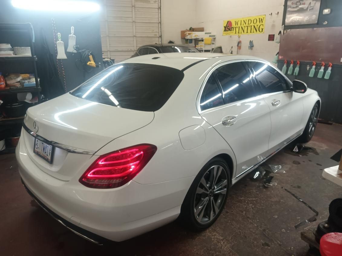 A white mercedes benz is parked in a garage.