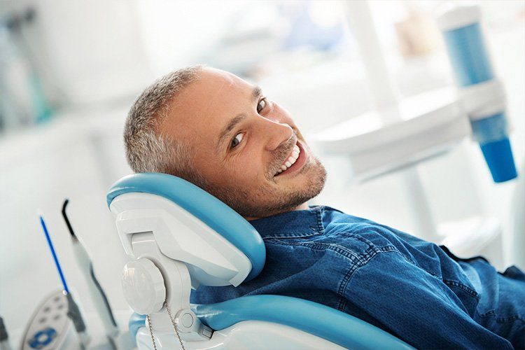 Elder man smiling laying on dental chair