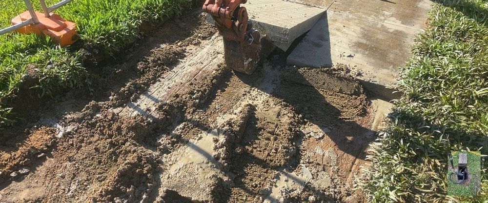 Excavator Digging a Hole in the Ground With a Shovel — Adzcom Civils in Portsmith, QLD