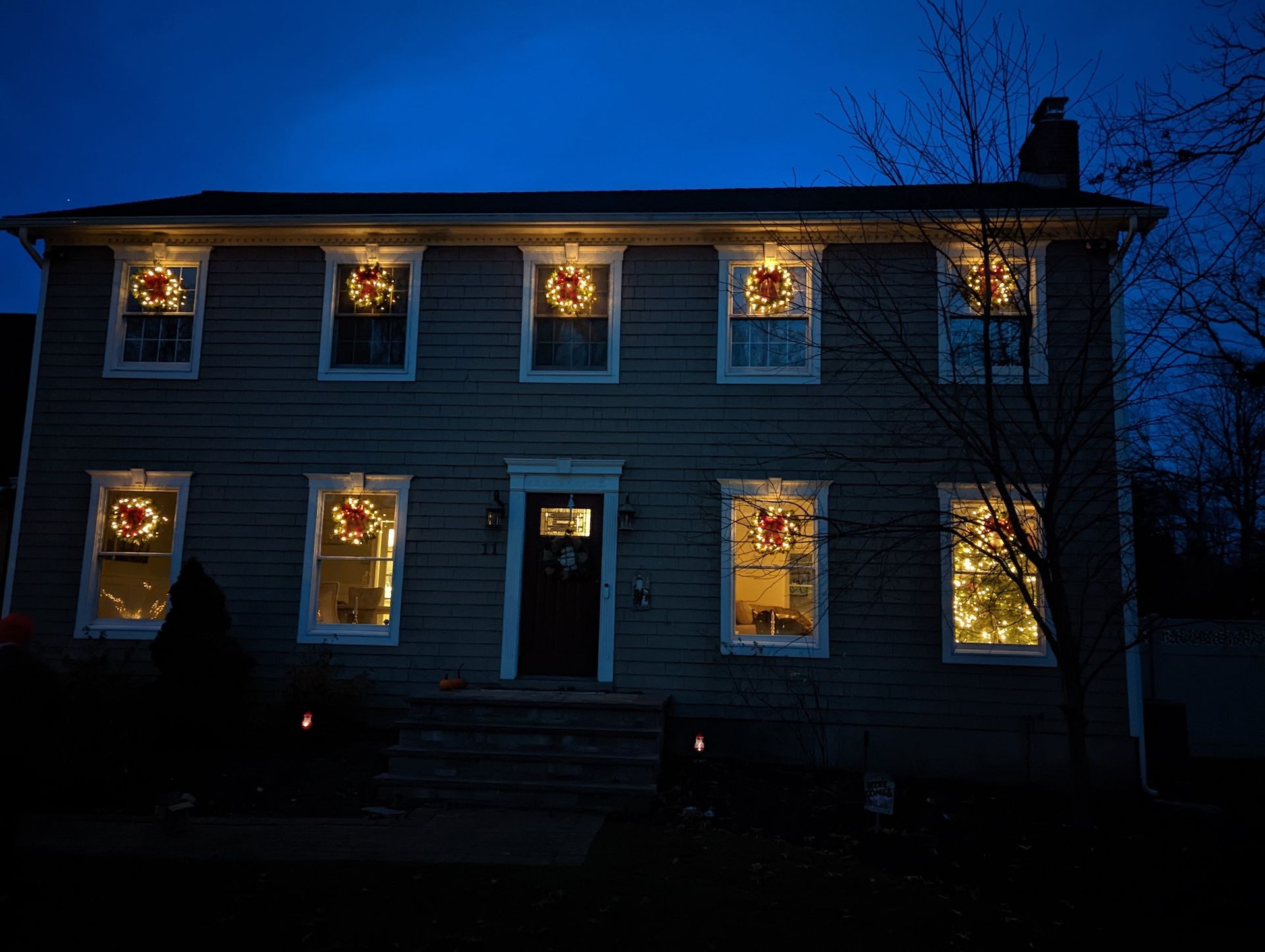 Wreath lighting in the front windows of home