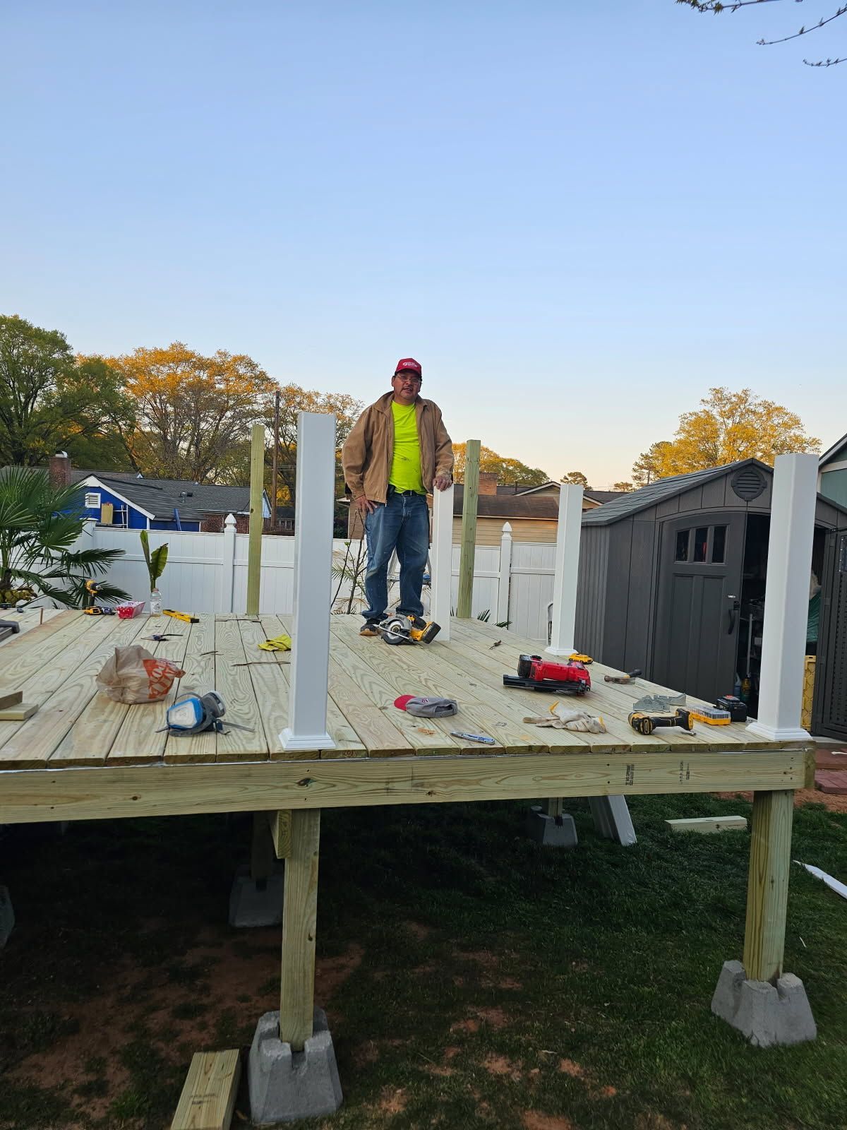 A man is standing on top of a wooden deck.